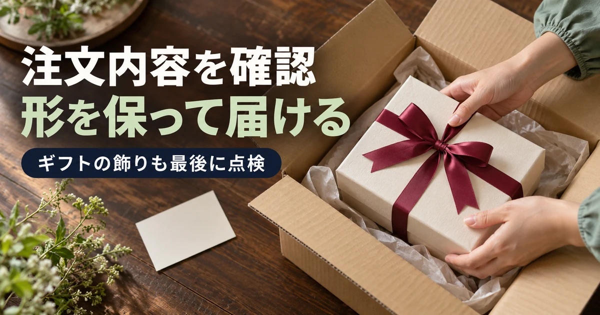 リボンの形を保ちながらギフト包装を外箱へ納めて最終確認する手元
